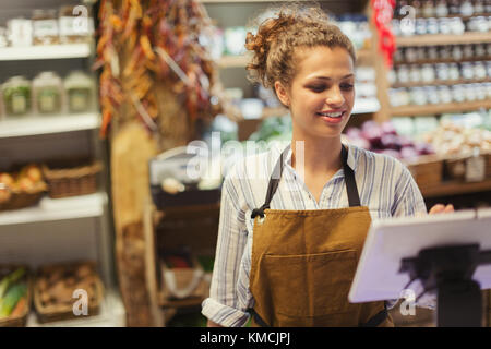 Weibliche Kassiererin mit Touchscreen-Kasse im Lebensmittelgeschäft Stockfoto