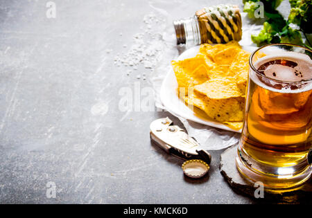 Bier. Bier und Chips auf einem alten Stein Hintergrund. Stockfoto
