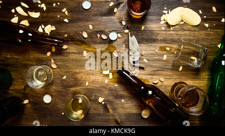 Bier Party. in den Prozess der Partei - verschüttetes Bier, Flaschenverschlüsse und übriggebliebene Chips auf dem Tisch. nach oben anzeigen Stockfoto