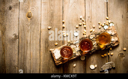 Bier Party. drei Bier auf Birke stand mit Pistazien um. top View Stockfoto