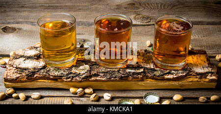 Bier Party. drei Bier auf Birke stand mit Pistazien um. Stockfoto