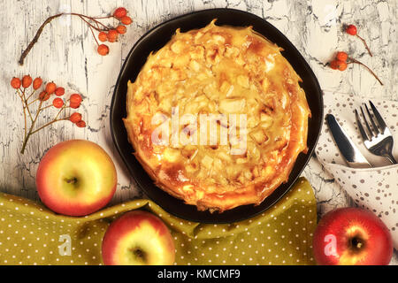 Hausgemachten Apfelkuchen mit äpfeln, Beeren und Bettwäsche Serviette auf Licht im Hintergrund. Ansicht von oben, getönten Bild. Stockfoto