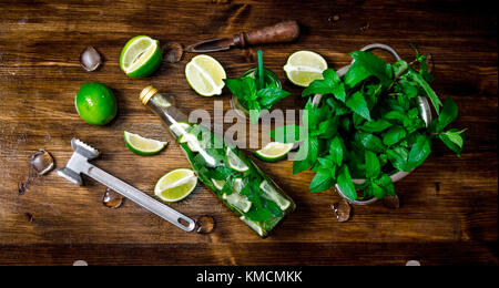 Mojito Cocktail. Zutaten zum Kochen - Limetten, Minze, Hammer, Rum auf der hölzernen Hintergrund. top View Stockfoto