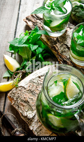 Das Konzept der Mojito cocktail Cocktail auf einem Stand aus Holz mit Limetten und Minze. Stockfoto