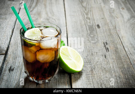 Cuba Libre Cocktail. frischen Cocktail mit Limetten und Minze auf Holztisch. freier Platz für Text. Stockfoto