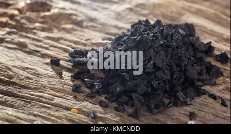 Stapel der schwarzen Lava Salz auf hölzernen Tisch. Detailansicht. Stockfoto