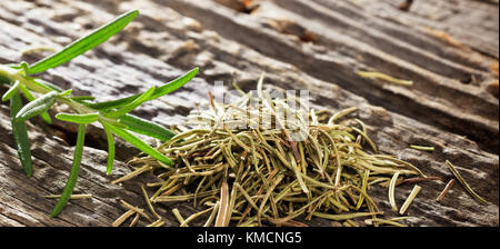 Nahaufnahme von Trocken- und frischem Rosmarin bei Tageslicht auf einer alten Holz- Oberfläche. Platz für Text. Stockfoto