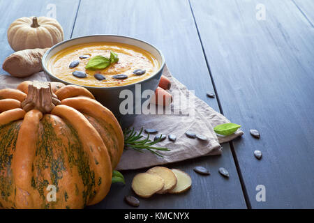 Pikante Kürbis creme Suppe mit Karotten und Ingwer gewürzt mit Kürbiskernen und Basilicum. Zutaten: Kürbis, Karotten, Ingwer, Zwiebeln, Knoblauch und Stockfoto