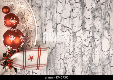 Dekorative Platte mit roten Christbaumkugeln und Serviette mit serviettenring auf rustikalen neutralen Hintergrund, Platz für Ihren Text Stockfoto