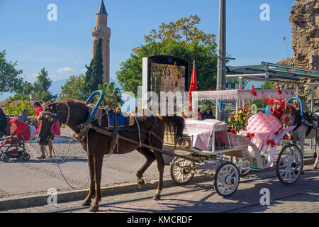 Dekoriert mit der Kutsche an der Straßenbahnhaltestelle warten, hinter das Yivli Minarett, Kaleici, der Altstadt von Antalya, Türkische Riviera, Türkei Stockfoto