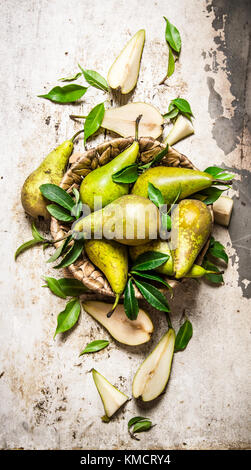 Birnen in einem Korb mit Blättern. Auf rustikalen Hintergrund. top View Stockfoto