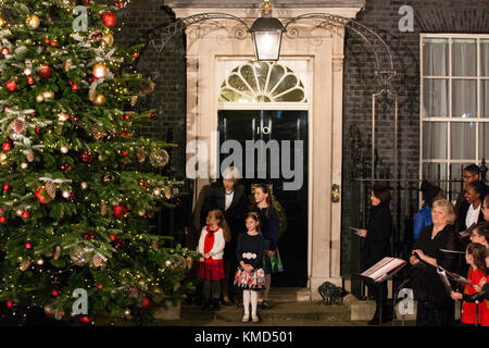 London, Großbritannien. 6 Dez, 2017. Premierminister Theresa May und Lily bo Morgan 5, Emily Wood, 7, und Sophie vysata, 8, bewundern Sie die beleuchteten Downing Street Weihnachtsbaum. Der Baum von Wales gespendet wurde-basierte Gower frische Weihnachtsbäume, der Verband Züchter der Weihnachtsbaum Winzer des Jahres ausgezeichnet. Es mit Kugeln und Lichtern geschmückt ist und gekrönt mit einem Stern und es ist das erste Mal, dass ein Weihnachtsbaum aus Wales außerhalb 10 Downing Street steht. Credit: Mark kerrison/alamy leben Nachrichten Stockfoto