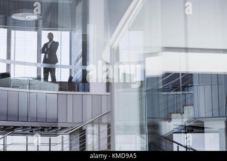 Selbstbewusster CEO Geschäftsmann steht mit gekreuzten Armen im modernen Büro Angezeigt Stockfoto