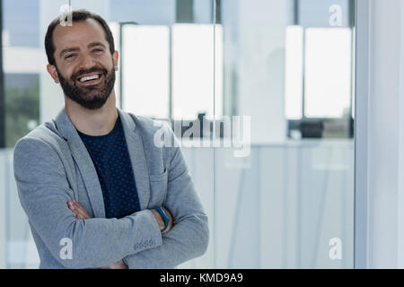 Portrait lächelnd, selbstbewusster Geschäftsmann im Büro Stockfoto