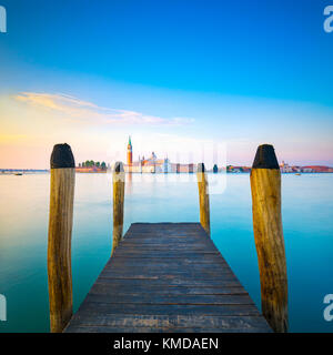 Die Lagune von Venedig, hölzernen Pier oder Jetty Pole und die Kirche San Giorgio Maggiore Wahrzeichen auf Hintergrund. Italien, Europa. Stockfoto