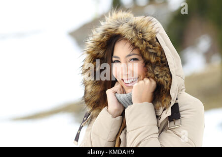 Glückliche Frau warm zu halten in einer verschneiten Winter auf dem Berg Stockfoto