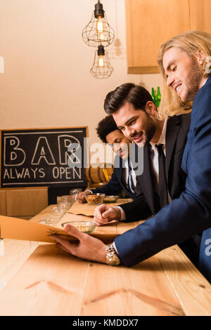 Geschäftsleute mit Menü in bar Stockfoto