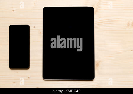 Smartphone und Tablet auf einem hölzernen Hintergrund Stockfoto