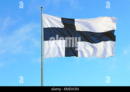 Nationalflagge von Finnland gegen den klaren, blauen Himmel am 6. Dezember 2017. Stockfoto