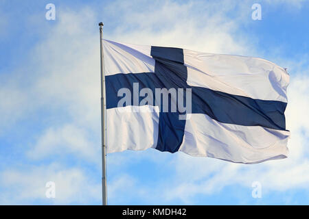 Nationalflagge von Finnland gegen den blauen Himmel mit weißen Wolken am 6. Dezember 2017. Stockfoto