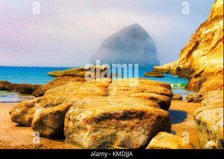 Nebel fängt Heu Rock Stapel direkt an der Küste vom Strand am Cape Kiwanda in Pacific Stadt an der Küste von Oregon an der Lüfterhaube Stockfoto