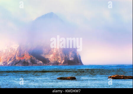 Nebel rollt enthüllt Haystack Rock am Cape Kiwanda in Pacific City, Oregon Stockfoto