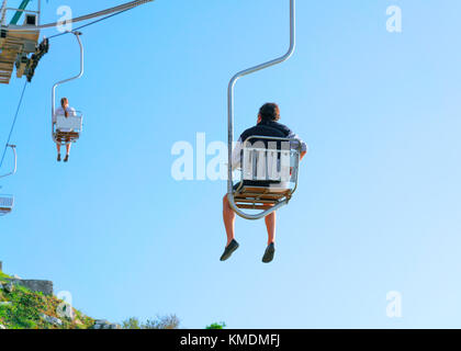 Menschen auf Seilbahn-Stuhl über die Insel Capri, Italien Stockfoto