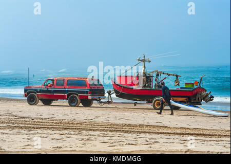 Pacific City, Oregon, USA - Juli 2, 2015: Ein roter und schwarzer 4-Rad SUV zieht ein Ruderboot Boot, mit der gleichen Farbe, auf dem Trailer. Ein Paddel Stockfoto