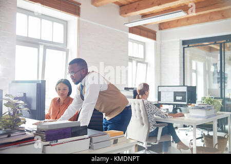 Unternehmer und Unternehmerin mit Computer im Büro Stockfoto