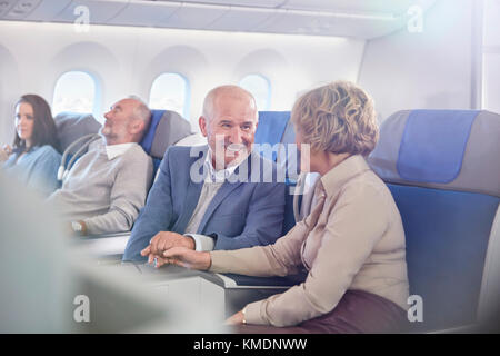 Liebevolles reifes Paar, das Hände auf Flugzeug hält Stockfoto