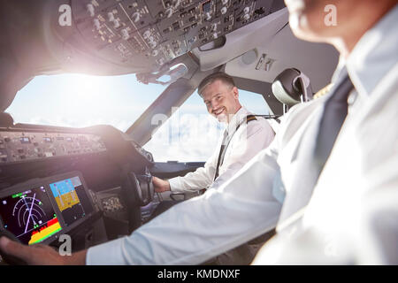 Portrait lächelnd, selbstbewusster Pilot im Flugzeug-Cockpit Stockfoto