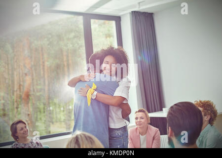 Mann und Frau umarmen in Gruppe Therapie Sitzung Stockfoto