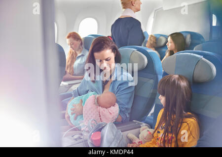 Mutter hält Baby im Flugzeug Stockfoto
