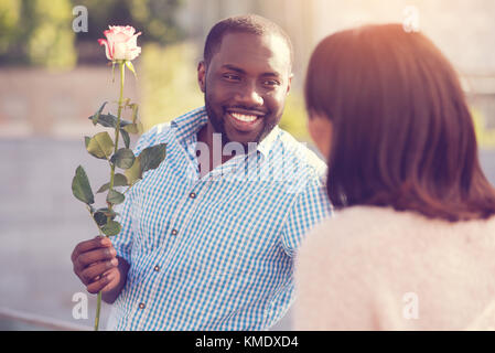 Attraktive fröhliche Mann hält ein Geschenk Stockfoto