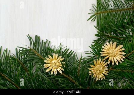 Blick von oben auf die Tanne weihnachten Zweige und handgemachte Sterne aus Stroh auf einem weißen Holz- Hintergrund Stockfoto