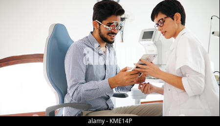 Aufmerksame optometrist Prüfung der weiblichen Patienten auf spaltlampe Stockfoto