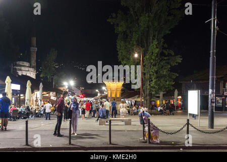 SARAJEVO, BOSNIEN UND HERZEGOWINA - 18. AUGUST 2017: Nacht Sebilj Brunnen und Baskarsija Square in Sarajewo, mit den Menschen um Stockfoto