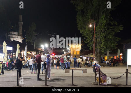 SARAJEVO, BOSNIEN UND HERZEGOWINA - 18. AUGUST 2017: Nacht Sebilj Brunnen und Baskarsija Square in Sarajewo, mit den Menschen um Stockfoto