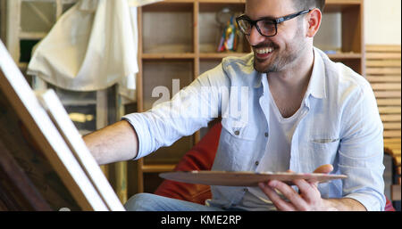 Portrait der männlichen Künstler arbeiten an Malerei im Studio Stockfoto