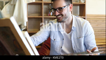 Portrait der männlichen Künstler arbeiten an Malerei im Studio Stockfoto