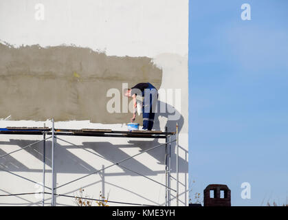 Slavjansk-na-kubani, Russland - 9. September 2016: gipser Bauarbeiter Wand in ein Geschäftsgebäude verputzt. Arbeiten auf Gerüsten. Stockfoto