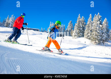 Happy little boy Skifahren mit seinem Vater auf Skiurlaub in den Alpen. Stockfoto