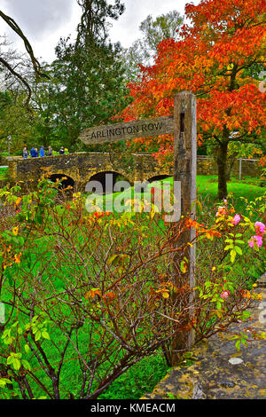 Alte hölzerne Wegweiser zu Arlington Row in Bibury, einem malerischen Cotswolds Dorf in England zeigt. Stockfoto