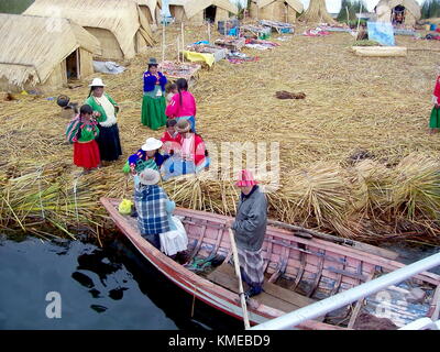 Puno, Peru, 3. Januar 2007: uros Frauen kaufen Lieferungen von einem Markt Boot entlang der Kante einer schwimmenden Insel, Titicacasee, Peru Stockfoto