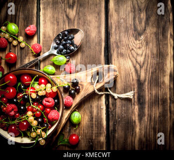 Beeren in einer Schale auf der Platine. Auf Holz- Hintergrund. Stockfoto