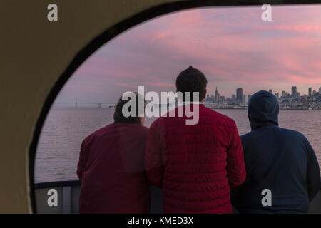 Rückansicht von drei Passagieren auf der Fähre von Sausalito nach San Francisco mit Blick auf die Stadt, Kalifornien, USA Stockfoto