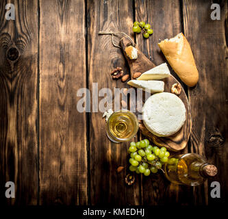 Ziegenkäse mit Weißwein und Muttern. Auf einem Holztisch. Stockfoto