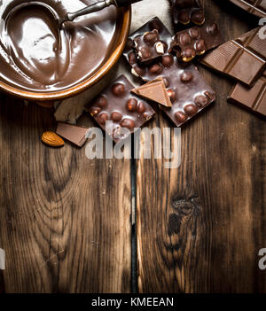 Schokoladencreme mit Scheiben von Schokolade und Nüssen. Auf einem Holztisch. Stockfoto