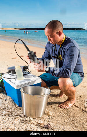 Wataru Kumagai vom State of Hawaii Department of Health Clean Water Branch, zeigt Wasserprobennahmen an hawaiianischen Stränden am Ala Moana Beach in Honolulu mit Instrumenten wie einem Trübungsmessgerät.für den vollen Umfang der Messungen, Laborarbeiten wurden extern durchgeführt. Stockfoto