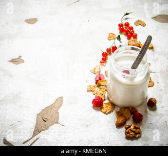 Milch Nachtisch mit Müsli, Nüsse und Beeren. Auf rustikalen Hintergrund. Stockfoto
